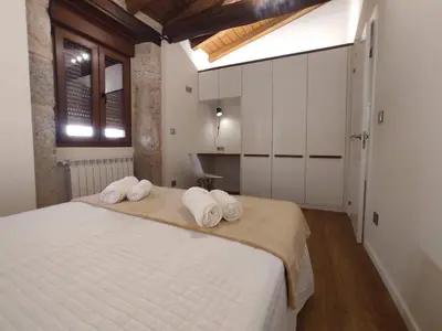 a bedroom with a large white bed with towels on it at Casa Lagarto, (Ribeira Sacra), Taboada in Taboada