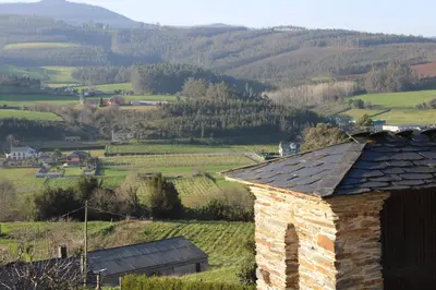 a stone building in a field with mountains in the background at De la Osa Hotel in Abres