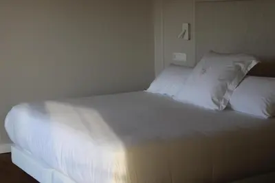a bed with white sheets and pillows in a room at De la Osa Hotel in Abres