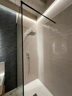 a bathroom with a shower with a glass door at De la Osa Hotel in Abres