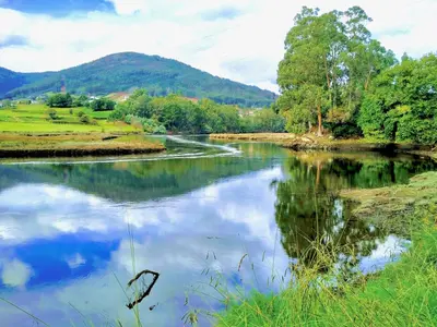 a river with a reflection of the sky in the water at The Cliffs - Mansión del Indiano I in Viveiro