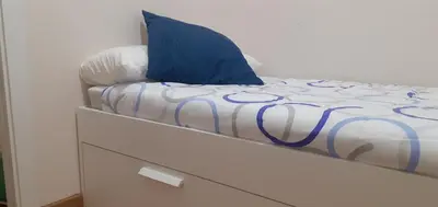 a bed with a blue pillow on top of a dresser at LOFT FRIOL in Friol