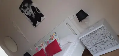 a white bedroom with a white bed with red pillows at LOFT FRIOL in Friol