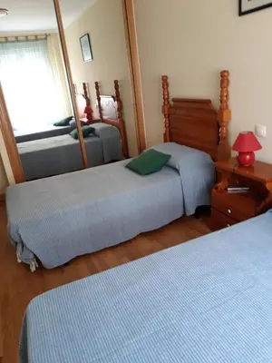 a bedroom with two beds and a mirror at En primera linea de la playa Rapadoira in Foz