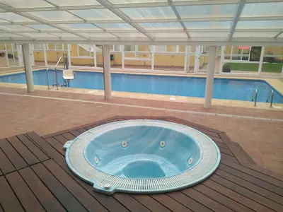 a large hot tub in front of a swimming pool at En primera linea de la playa Rapadoira in Foz