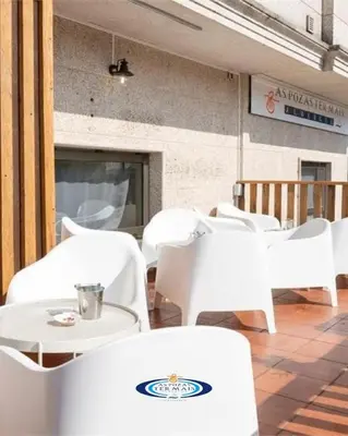 a blue room with chairs and tables in a restaurant at Albergue As Pozas Termais in Caldas de Reis