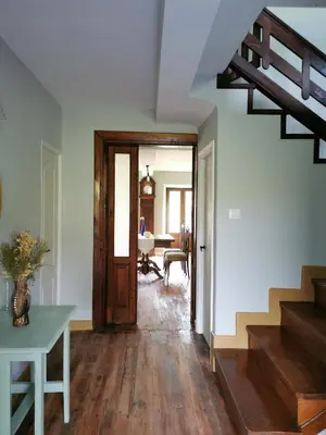 a hallway with a staircase and a room with a table at La casona El Espín in Serandinas