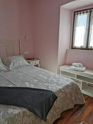 a bedroom with a bed and two tables and a window at La casona El Espín in Serandinas
