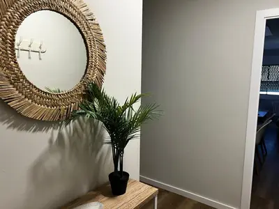 a mirror on a wall next to a table with a plant at Oktheway Ultreia in Sarria