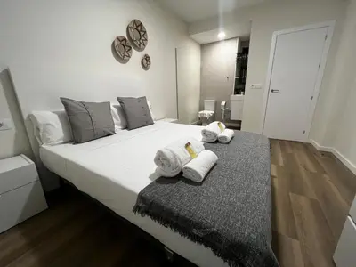 a bedroom with a large white bed with towels on it at Oktheway Ultreia in Sarria