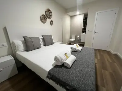 a bedroom with a large white bed with towels on it at Oktheway Ultreia in Sarria