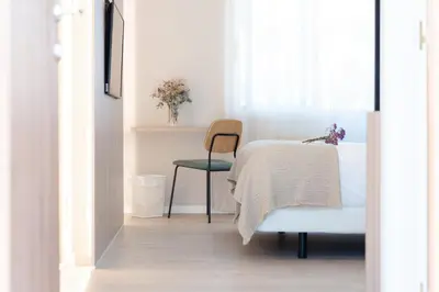 a bedroom with a bed and a chair and a window at Makkan Club in Oleiros