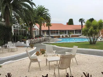 a group of chairs and a table in front of a resort at Makkan Club in Oleiros
