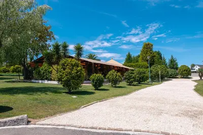 a building in a park with trees and a sidewalk at Makkan Club in Oleiros
