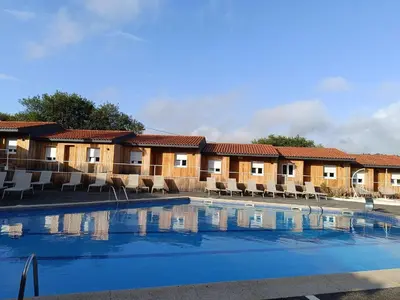 a hotel with a swimming pool in front of a building at Makkan Club in Oleiros