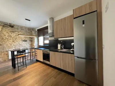 a kitchen with a stainless steel refrigerator and a table at Casa Os Chocolateiros in Ourense