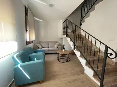 a living room with a blue couch and stairs at Casa Os Chocolateiros in Ourense