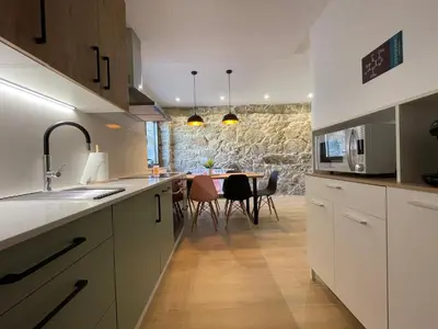 a kitchen with a table and a dining room at Casa Os Chocolateiros in Ourense