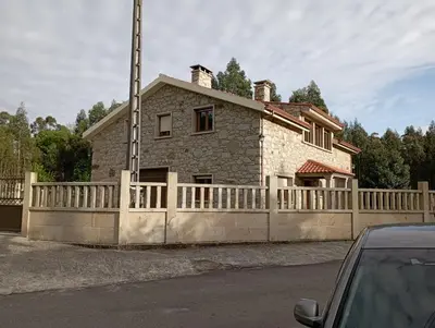 a house with a fence in front of it at As Pias in Pontevedra