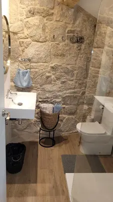 a stone bathroom with a sink and a toilet at Casa Leirón in Parada del Sil