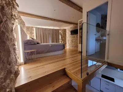 a bedroom with a bed and a wooden floor at Casa Leirón in Parada del Sil