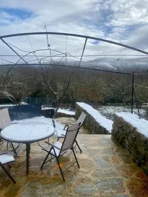 a table and chairs on a patio with snow at Casa Leirón in Parada del Sil