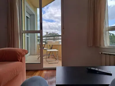 a living room with a view of a balcony at Apartamento con vistas, amplio y luminoso in Monforte de Lemos