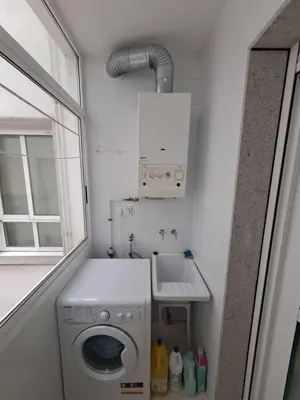 a small bathroom with a washing machine and a sink at Apartamento con vistas, amplio y luminoso in Monforte de Lemos