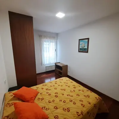 a bedroom with a bed with orange sheets and a window at Apartamento con vistas, amplio y luminoso in Monforte de Lemos