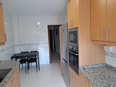 a kitchen with a stove and a table with chairs at Apartamento con vistas, amplio y luminoso in Monforte de Lemos