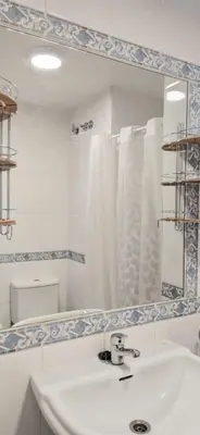a white bathroom with a sink and a mirror at La morada del Museo in Ponferrada