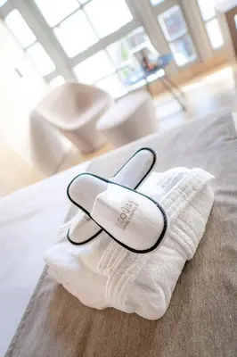 a pair of white shoes sitting on a pillow on a bed at ACOUGA Hotel Boutique in Celanova