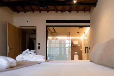 a bedroom with a bed with white sheets on it at ACOUGA Hotel Boutique in Celanova