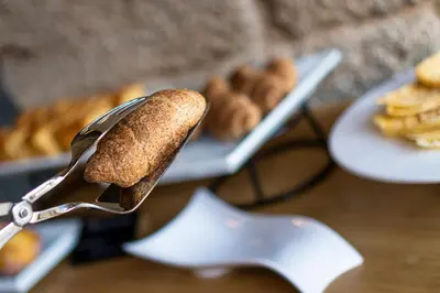 a hot dog sticking out of a spatula next to a plate of food at ACOUGA Hotel Boutique in Celanova