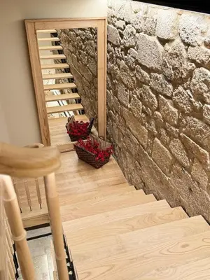 a staircase leading up to a brick wall with two baskets of flowers at ACOUGA Hotel Boutique in Celanova
