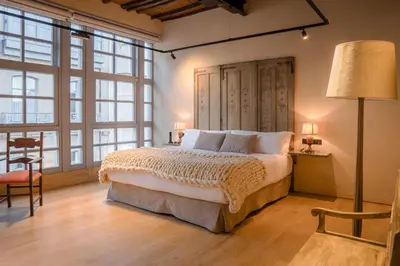 a bedroom with a large bed and large windows at ACOUGA Hotel Boutique in Celanova
