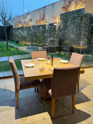 a dining room table with chairs and a large window at ACOUGA Hotel Boutique in Celanova