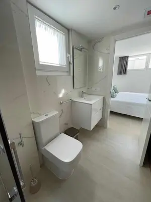 a bathroom with a toilet and a sink and a bed at Adosado A ( 5 hab) in Foz