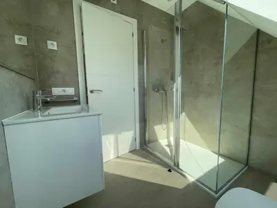 a bathroom with a shower with a sink and a glass shower stall at Adosado A ( 5 hab) in Foz