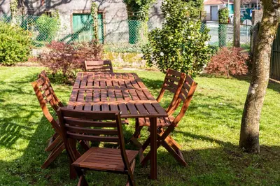 a wooden table and chairs sitting in the grass at Casa das Regueiras in Santiago de Compostela
