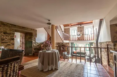 a living room with a table and a staircase at Casa das Regueiras in Santiago de Compostela
