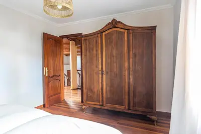 a bedroom with a wooden cabinet and a bed at Casa das Regueiras in Santiago de Compostela