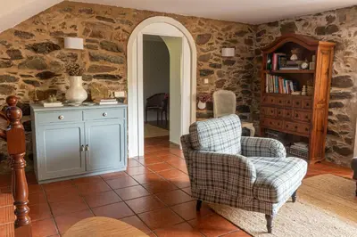 a living room with two chairs and a book shelf at Casa das Regueiras in Santiago de Compostela