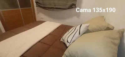 a bed with two pillows in a room at DÚPLEX ÁTICO XANA FOZ con terraza 80 m2 privada y vistas a la ría in Foz