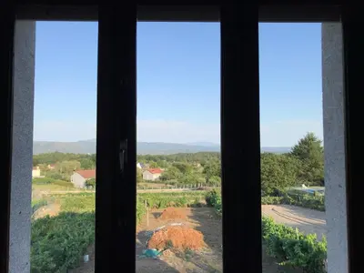 a window looking out at a view of a field at Casa en Cambeo in Ourense