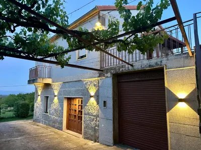 a building with a garage door and a balcony at Casa en Cambeo in Ourense