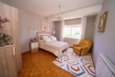 a bedroom with a bed and a chair at Antoxos Sacra Home I in Chantada