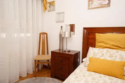 a bedroom with a bed and a chair at Antoxos Sacra Home I in Chantada