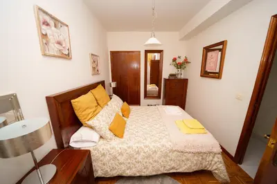 a bedroom with a bed with yellow pillows at Antoxos Sacra Home I in Chantada