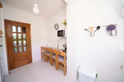 a kitchen with white walls and a wooden door at Antoxos Sacra Home I in Chantada